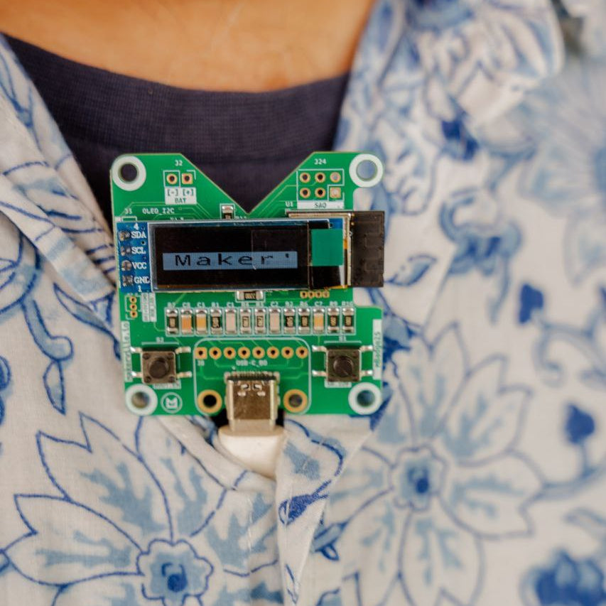 Electronic badge with 'Makers' writteen on a display